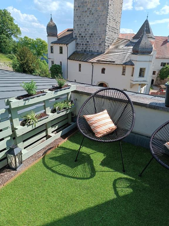a patio with two chairs on a roof at Burg & Tal Panorama in Riedenburg