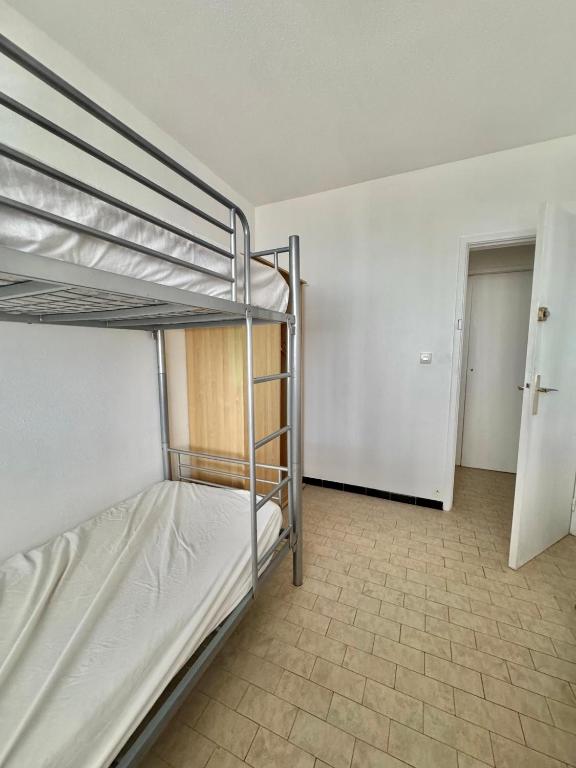 a bedroom with two bunk beds and a hallway at Aqua Appartement in La Grande-Motte