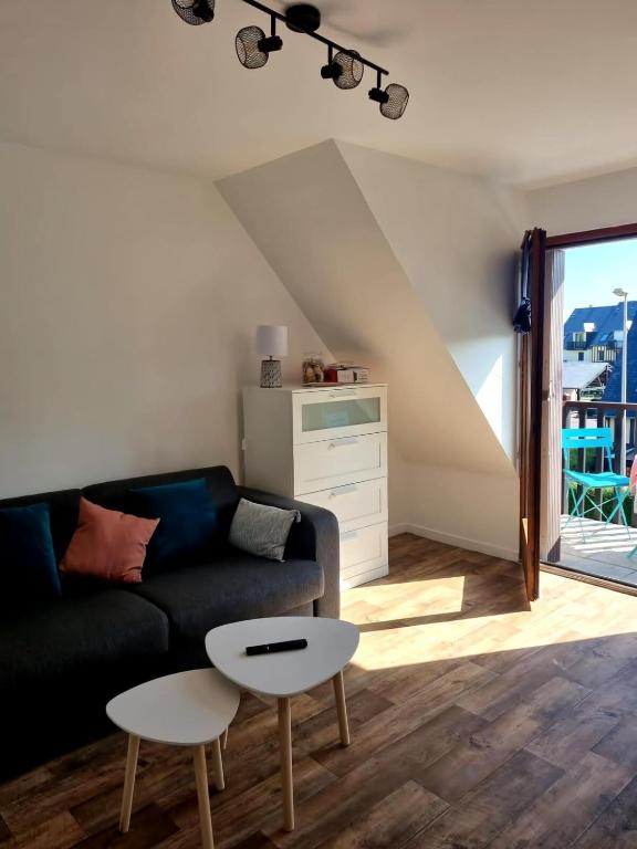 un salon avec un canapé et une table dans l'établissement Studio à côté de la thalasso, à Cabourg