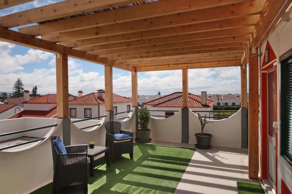 a patio with a wooden pergola and a table and chairs at Casa do Calço in Ponta Delgada