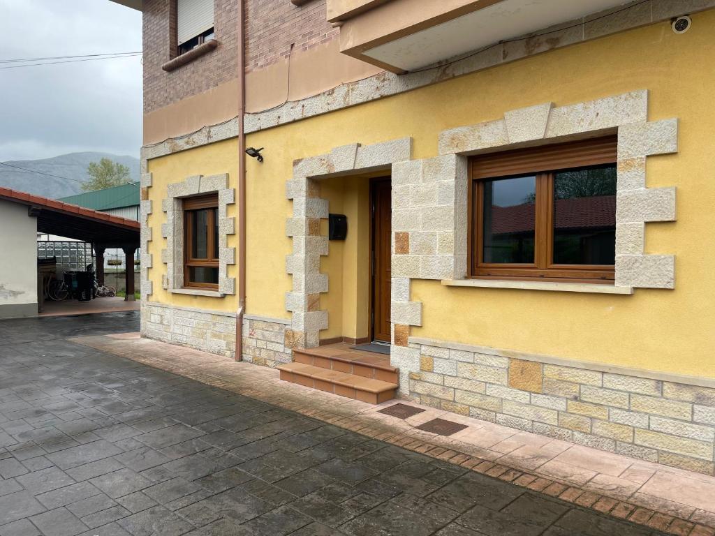 a yellow building with a window on the side of it at La Casuca de Corrales in Los Corrales de Buelna
