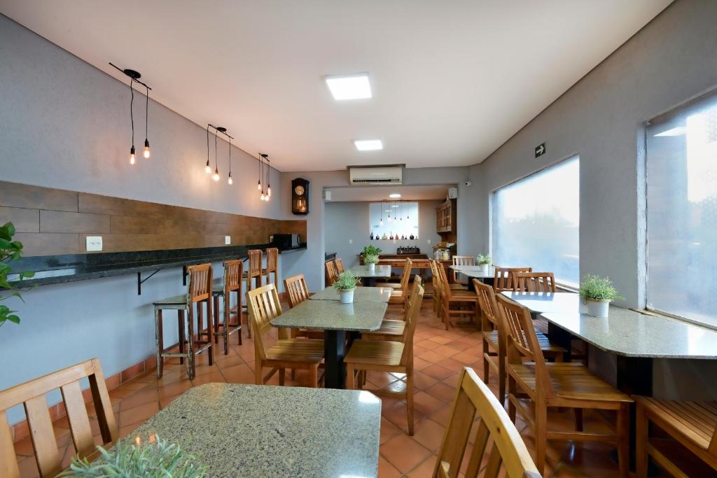 una sala da pranzo con tavoli e sedie in un ristorante di HOTEL SENADoR a Ribeirão Preto