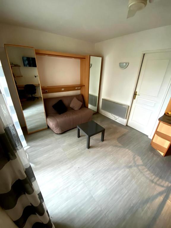 une petite pièce avec un lit et une table dans l'établissement T2 avec parking sous sol et piscine dans résidence, à La Rochelle