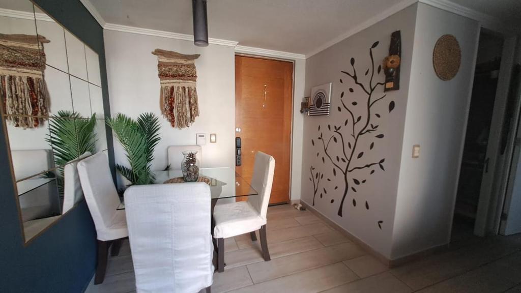 Un comedor con una mesa y sillas blancas. en Departamento Ñuñoa -Grecia, en Santiago