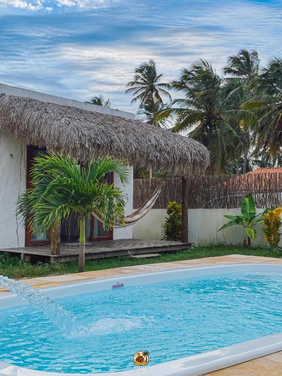 a resort with a swimming pool in front of a house at Moitas chalés in Amontada