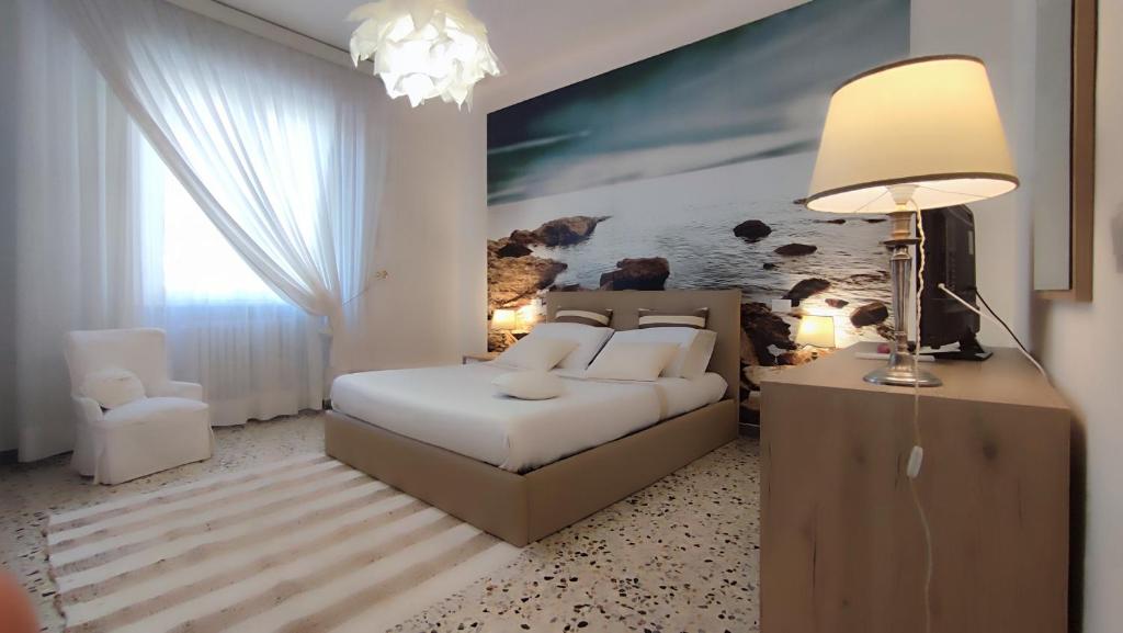 een slaapkamer met een bed, een bank en een lamp bij A casa di Ezio e Paola in La Spezia