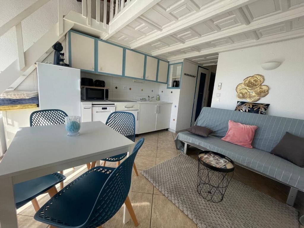 un salon avec un canapé, une table et des chaises dans l'établissement Le Golfe - Ile des Loisirs - Clim - Piscine - Luna Park, au Cap d'Agde