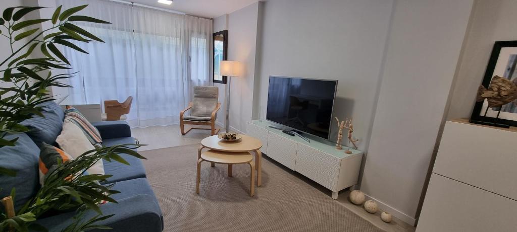 a living room with a couch and a tv and a table at Salinetas apartamento junto al mar in Telde