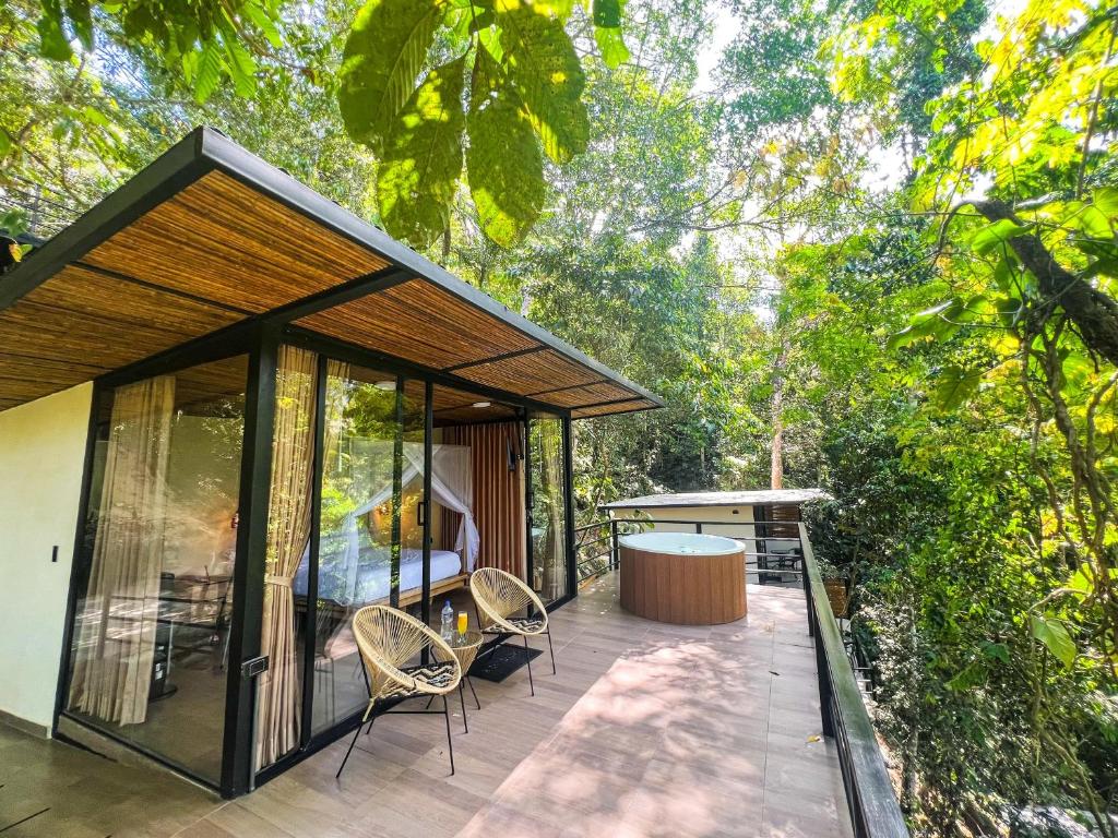 a house with a deck with chairs and a table at Rincon de la Sierra Minca in Minca
