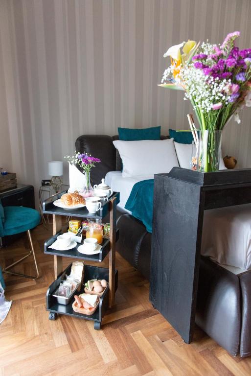 Pokój z łóżkiem i stołem z jedzeniem i kwiatami w obiekcie Suite room w mieście Aversa