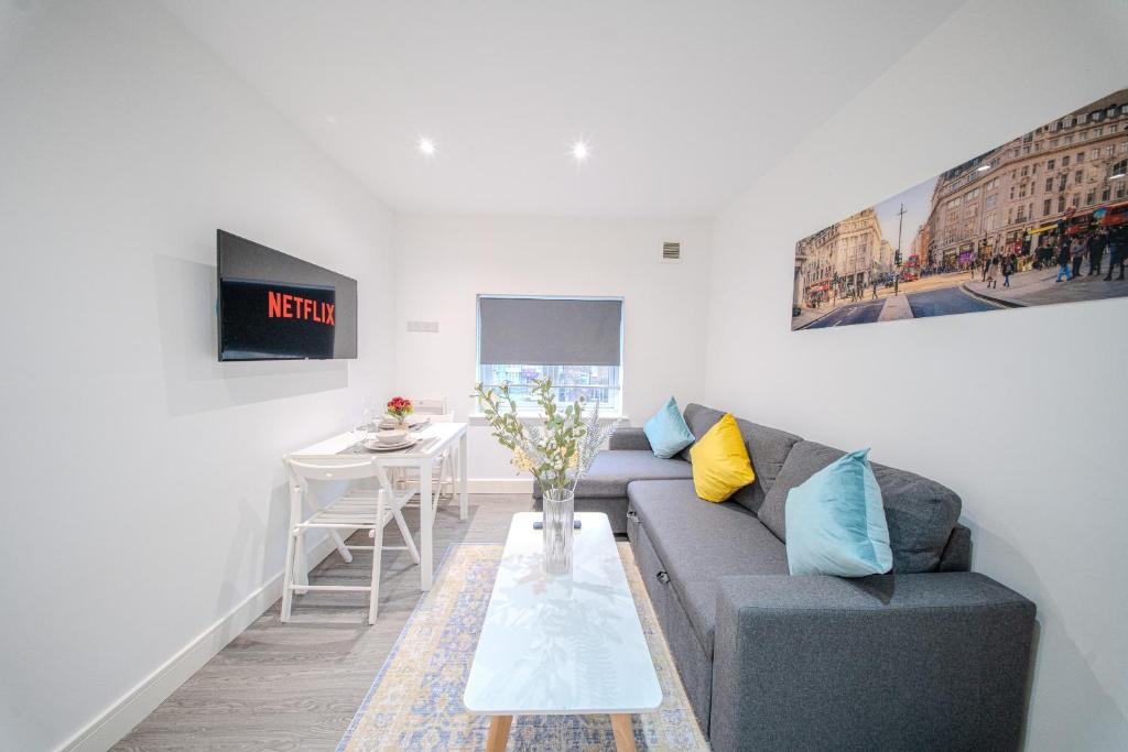 a living room with a couch and a table at Ilford Luxury Apartments in Ilford