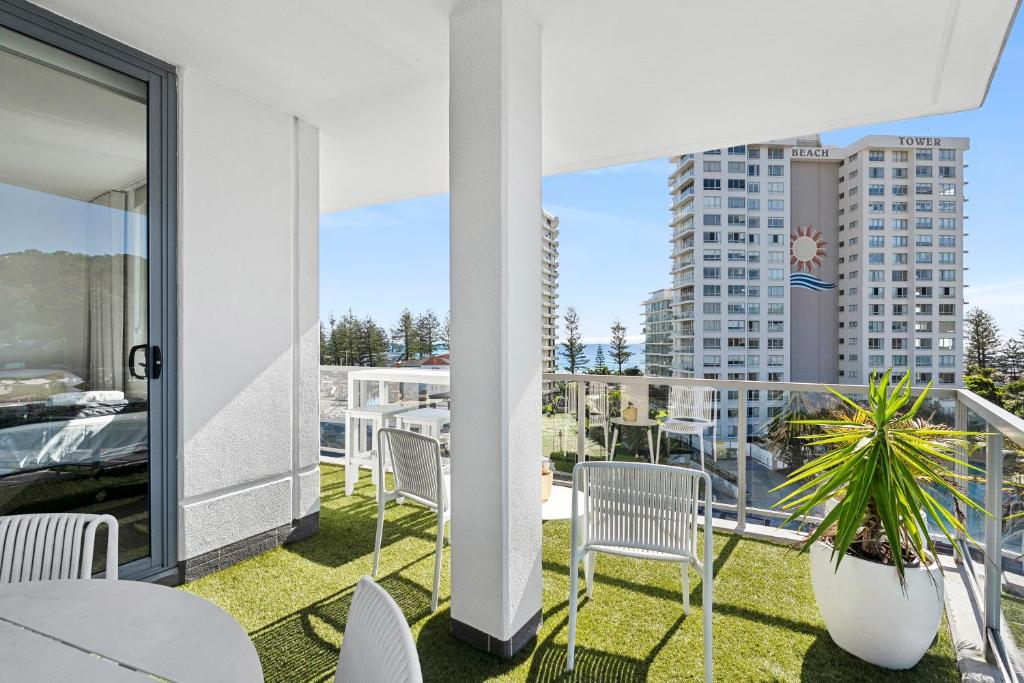 a balcony with chairs and tables and a view of a building at Lunakai in Gold Coast