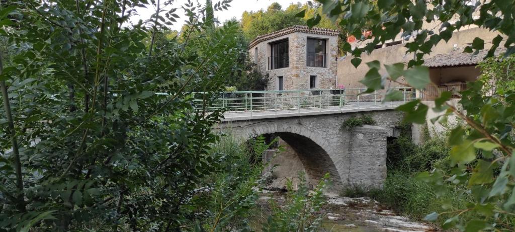 un ponte sopra un fiume con un edificio sopra di Maison en Drôme provençale a Eygaliers