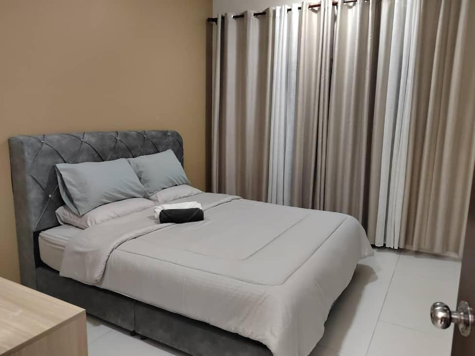 a bed with a black headboard in a bedroom at Ana Homestay in Seri Manjung