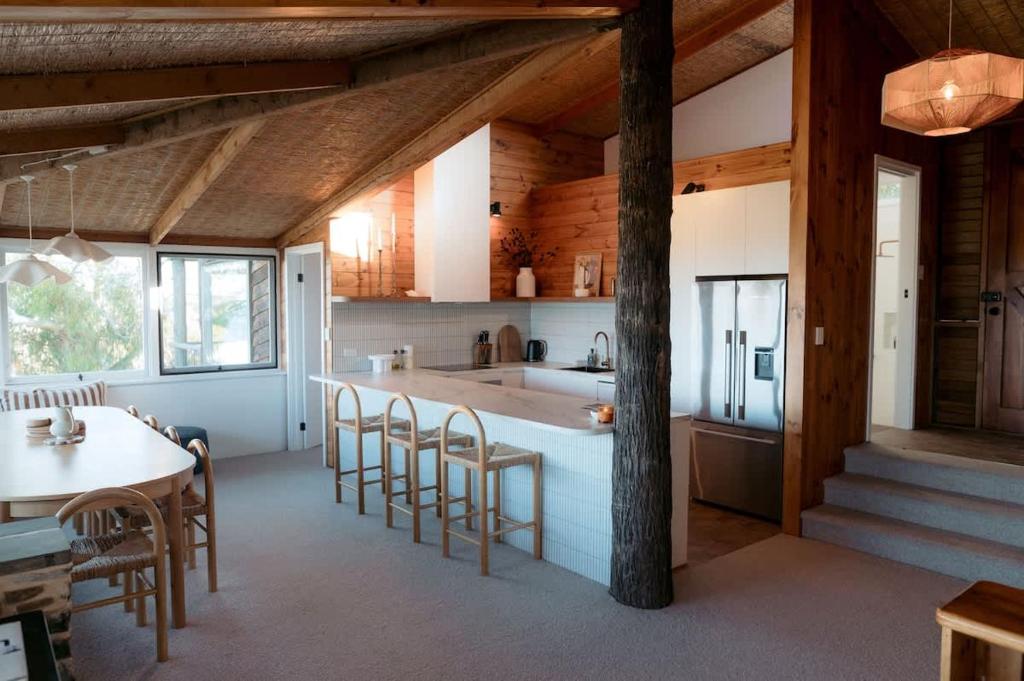 a kitchen and dining room with a table and chairs at Coastal Tree House- Short Stroll to Beach in Encounter Bay