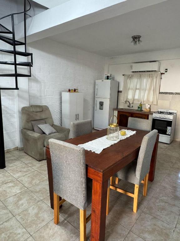 a kitchen with a wooden table and chairs in a room at Victoria Apart in Esquina
