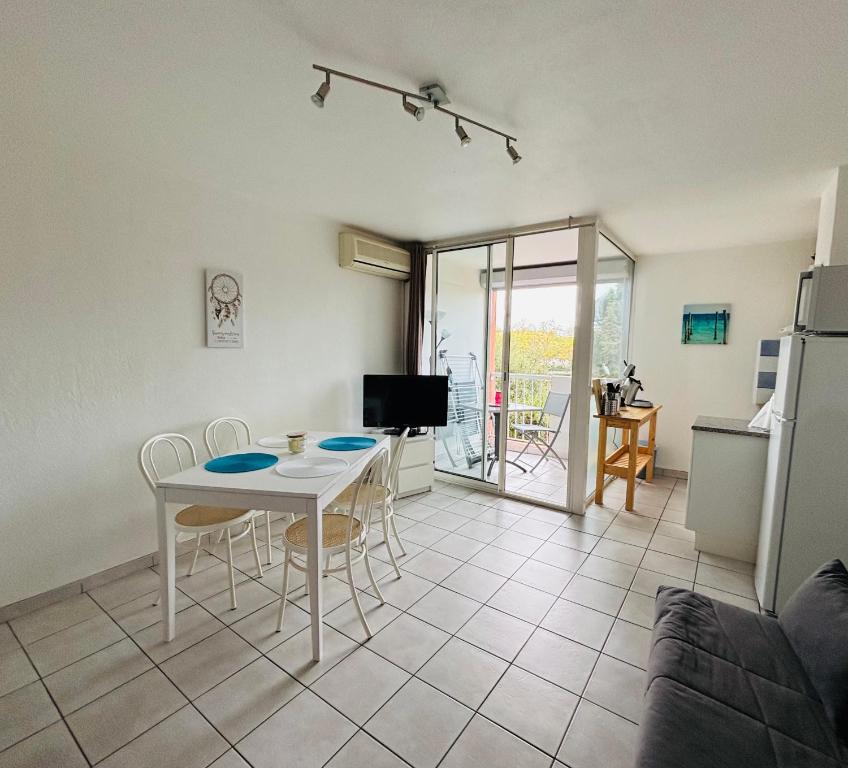 une cuisine et un salon avec une table et des chaises dans l'établissement Au cœur du Cap, au Cap d'Agde