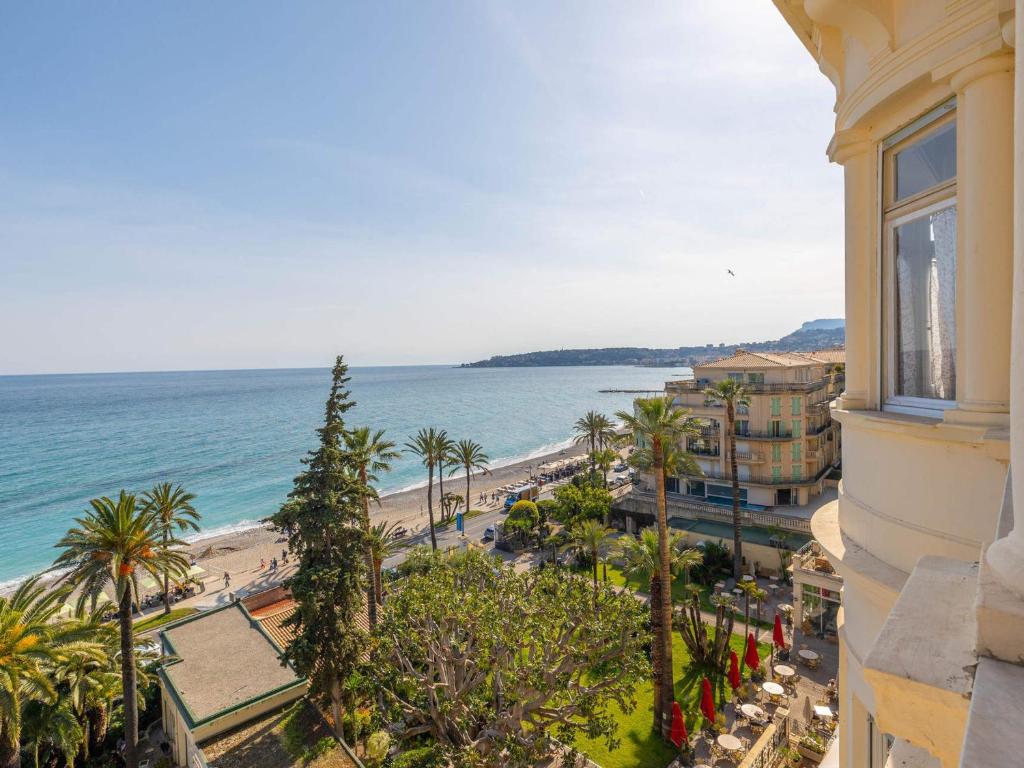 une vue sur une plage et l'océan depuis un immeuble dans l'établissement Appartement 4 pers à Menton, 60 m² - FR-1-196-378, à Menton
