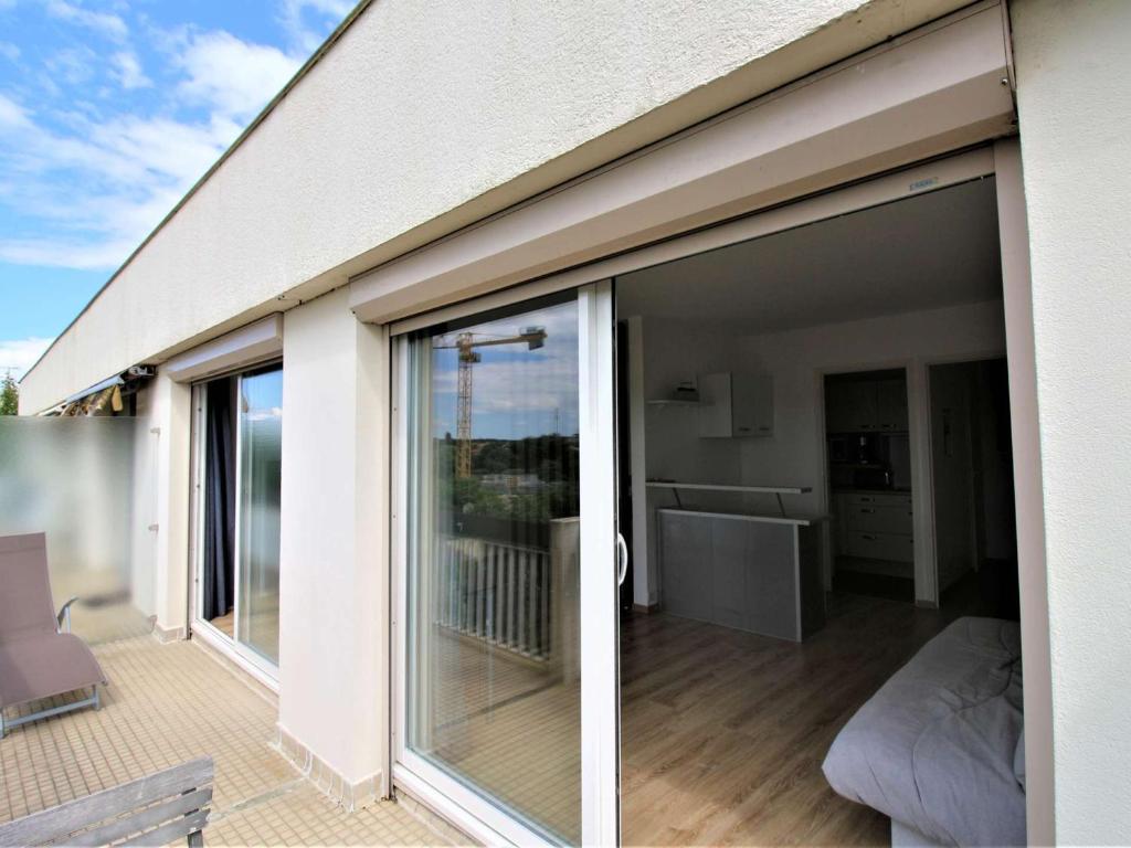 d'un balcon avec des portes coulissantes en verre sur une maison. dans l'établissement Appartement rénové avec terrasse à Royan - FR-1-494-206, à Royan