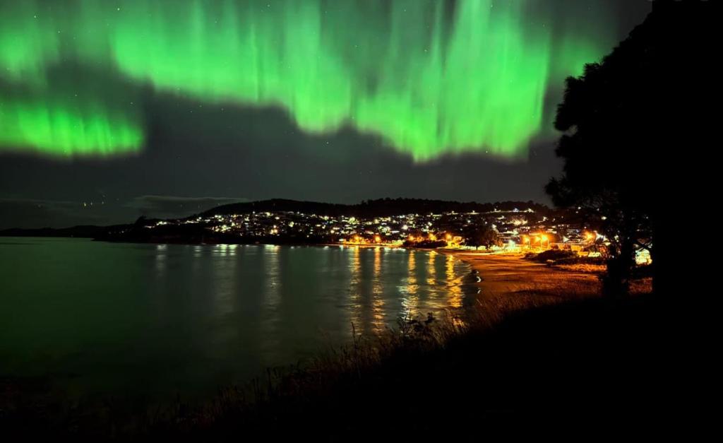 an image of the northern lights over a body of water at Ocean Views 20kms from CBD Sleeps 10 in Kingston Beach