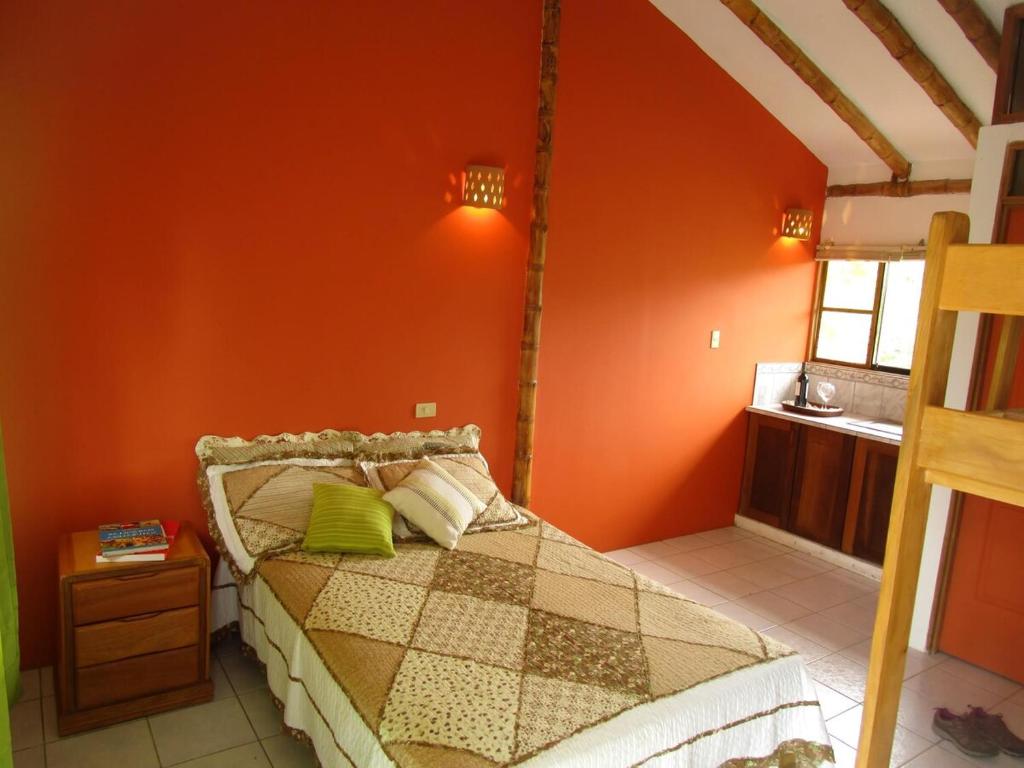 a bedroom with a bed with an orange wall at Snug Bungalow - 4 people - Pool - SuperHost in Mala