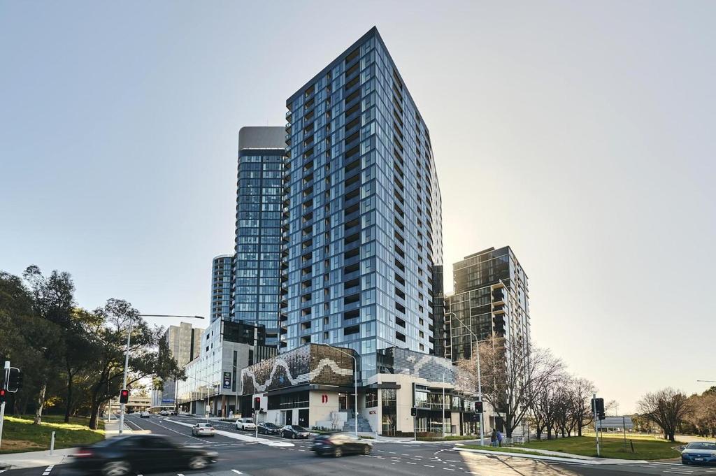 a tall building on a city street with cars at Town Center 1 Bedroom Cozy Home in Belconnen