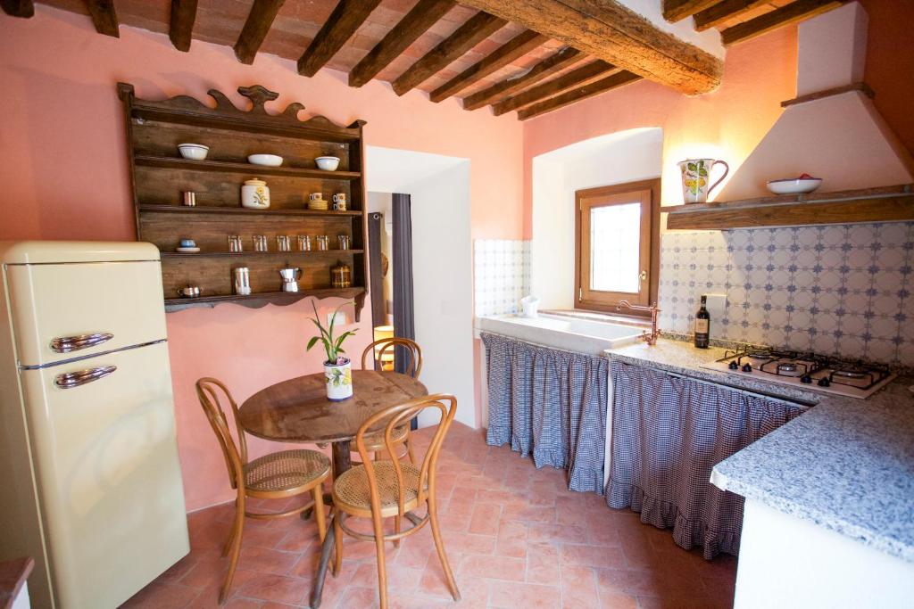 a kitchen with a table and chairs and a refrigerator at San Cerbone in Porto Azzurro
