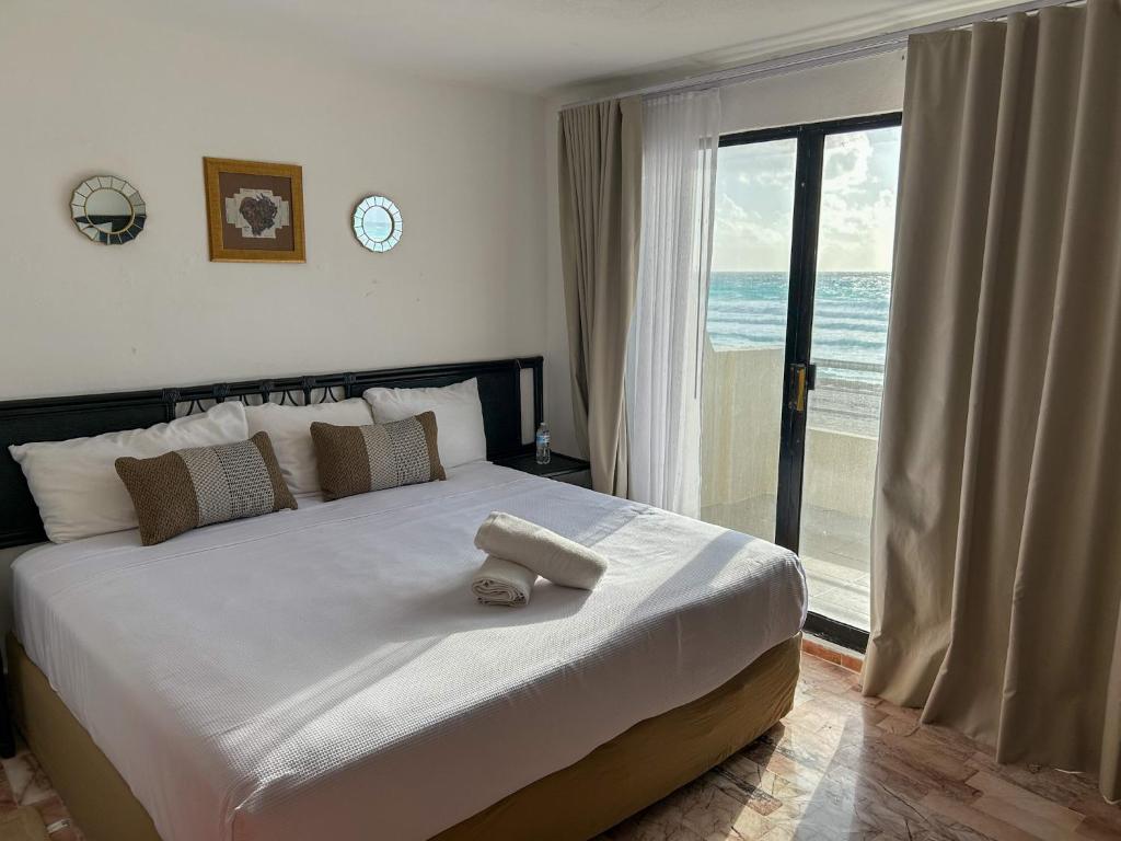 Un dormitorio con una cama grande con vista al mar. en Deluxe Ocean Villas Marlin, en Cancún