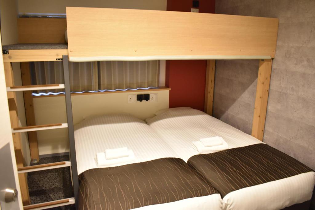 Postel nebo postele na pokoji v ubytování Shinsaibashi House