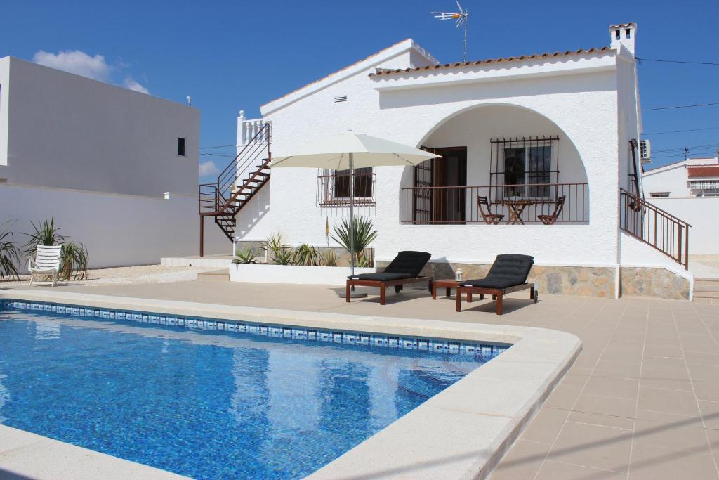 a villa with a swimming pool in front of a house at Casa Giner in Ciudad Quesada