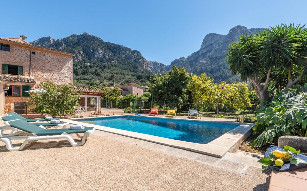 a villa with a swimming pool with mountains in the background at Finca Xesca in Sóller