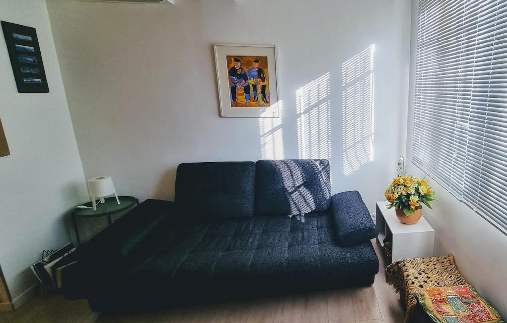 un salon avec un canapé bleu dans une pièce dans l'établissement Appartement 2 pièces cannes, à Cannes