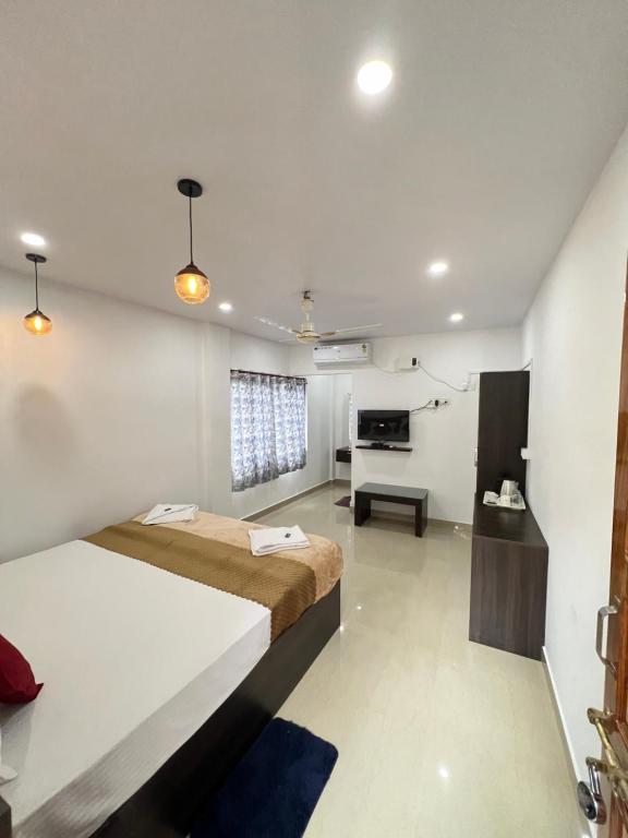 ポートブレアにあるSea Shore Residencyの大きなベッドと机のある寝室