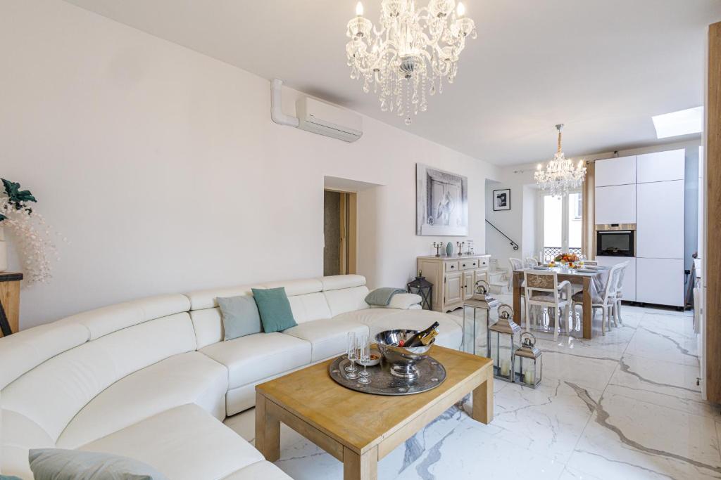 un salon avec un canapé blanc et une table dans l'établissement SICARDI - Elegant apartment in old town, à Menton