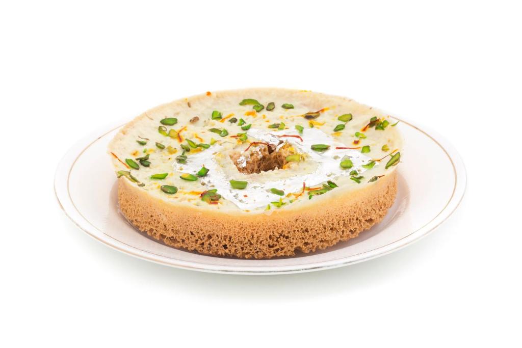 a cake on a plate on a white background at Collection O Tip Top in Jaipur