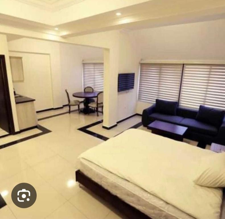 um quarto com uma cama, um sofá e uma mesa em Taj suite hotel em Al Qanţārī