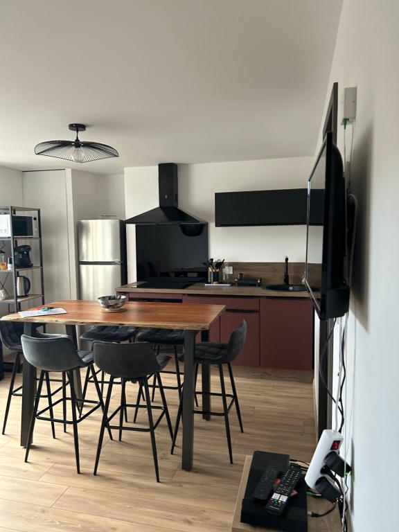 une cuisine et une salle à manger avec une table et des chaises dans l'établissement Les vosgiens, à Gérardmer