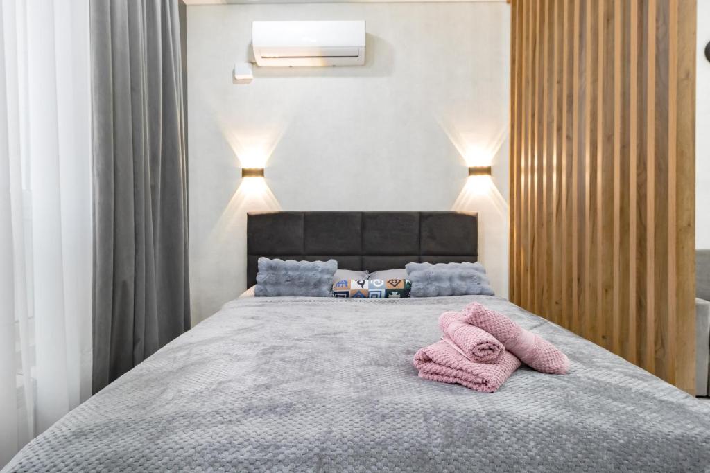 Красотка в сером في أستانا: غرفة نوم بها سرير عليه منشفتان