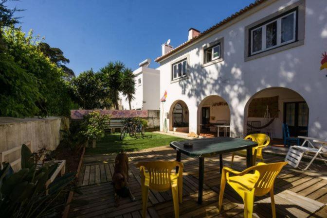 eine Terrasse mit einem Tisch und Stühlen sowie ein Haus in der Unterkunft Cascais Boutique Hostel in Cascais