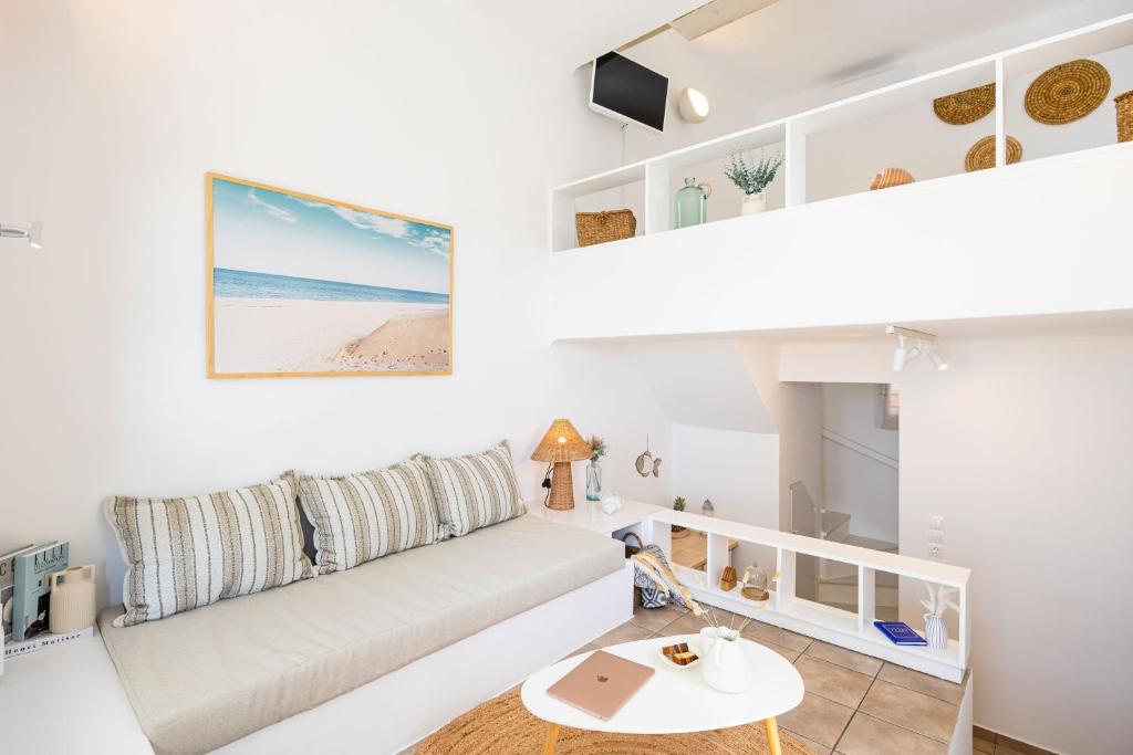 Una sala de estar blanca con un sofá y una mesa. en Sand Beach House, Naxos Stelida, en Stelida