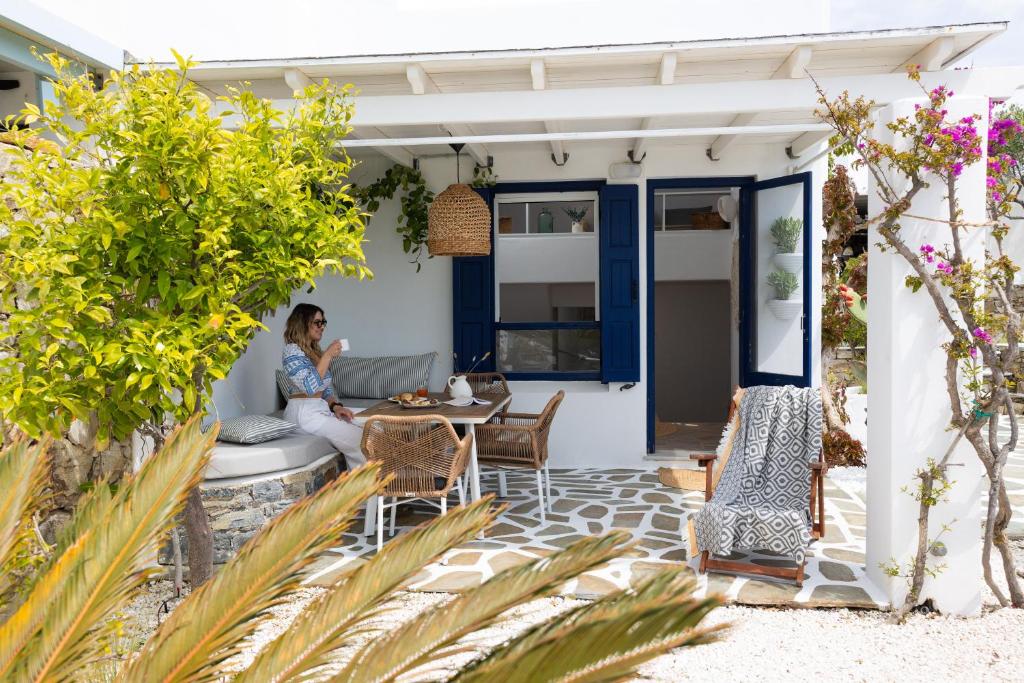a woman sitting on the porch of a house at Sand Beach House, Naxos Stelida in Stelida