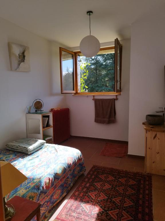 - une chambre avec un lit, une fenêtre et un tapis dans l'établissement Chambre ensoleillée au calme, à Lasalle