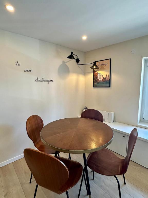 une salle à manger avec une table et des chaises en bois dans l'établissement Le Cocoon Strasbourgeois, à Strasbourg