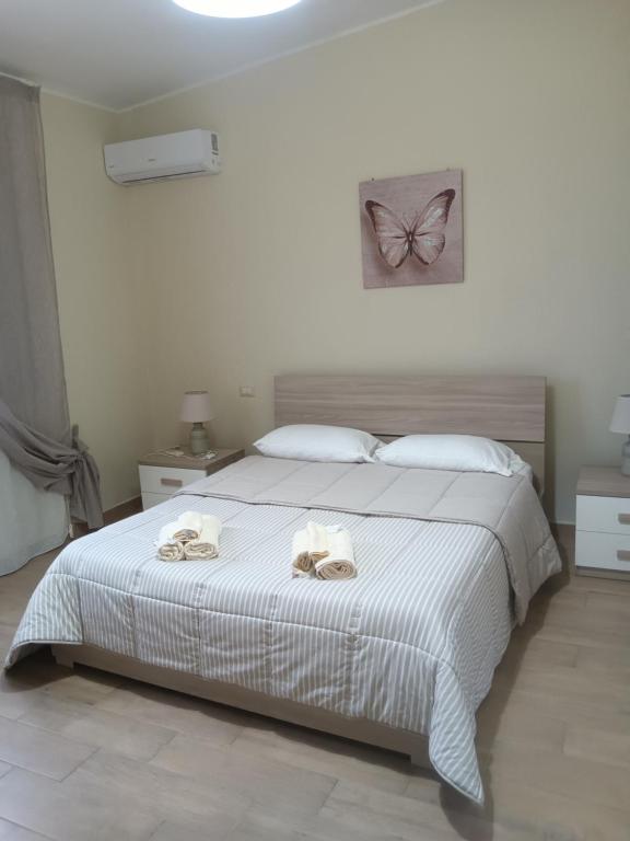 a bedroom with a bed with two towels on it at Luminoso Appartamento con Terrazza......C.U......Q2483 in Sìnnai