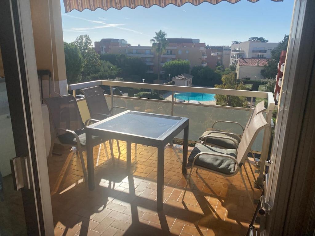 une table et des chaises sur un balcon avec vue dans l'établissement Le fidgi - T3 6 personnes Parking privé Clim Terrasse proche plages, à Cagnes-sur-Mer