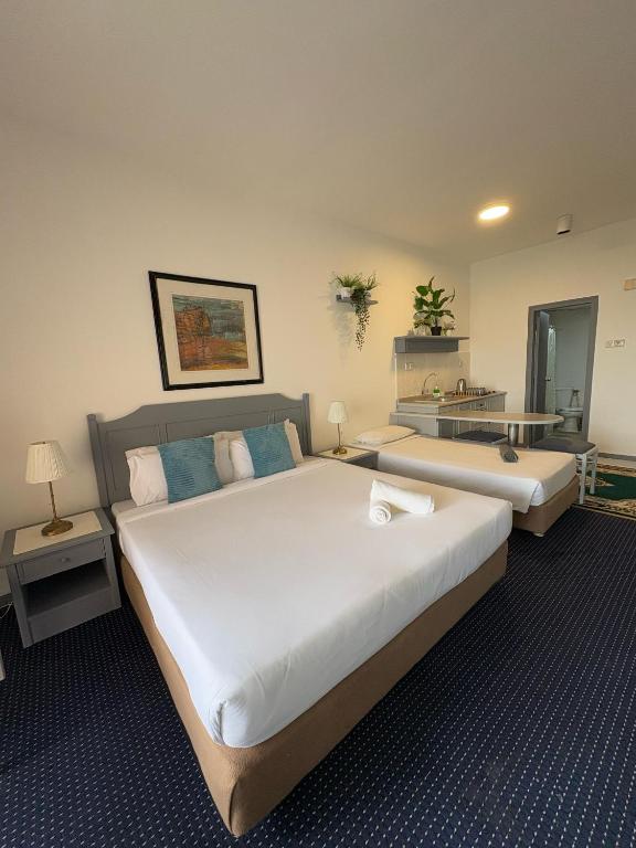 a large bedroom with two beds and a table at Rainbow Paradise Resort by Achlys Collection in Tanjung Bungah