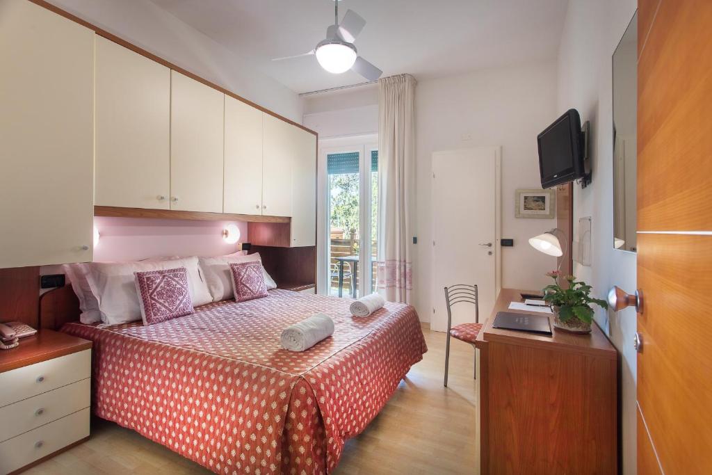 ミラノ・マリッティマにあるHotel Mon Reveのベッドルーム(ベッド1台、デスク、テレビ付)