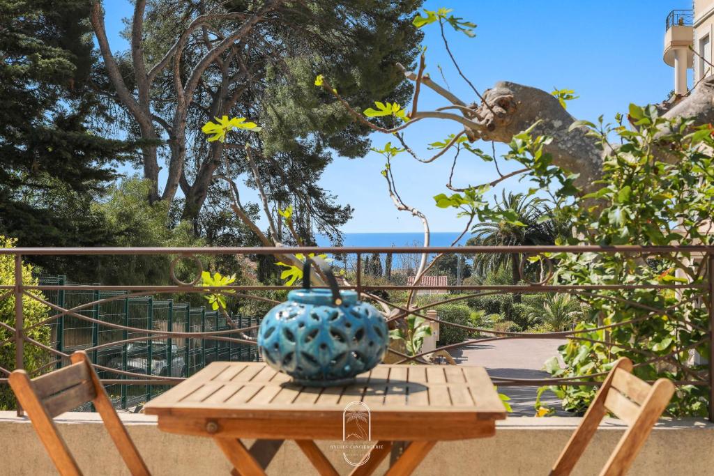 a table with a blue vase sitting on top of it at Maisonnette Saona vue mer plages 800m WiFi CLiM PK By HC in Carqueiranne