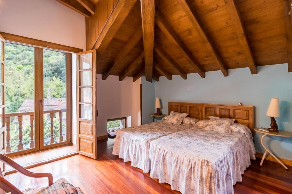 Un dormitorio con una cama y una ventana grande. en Casa El Agero, en Cabañes
