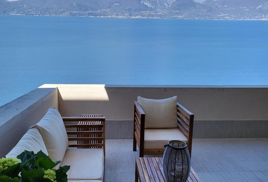 a balcony with a couch and a chair on a roof at La maison sur mer in Torri del Benaco